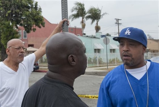 Donnell Alexander, right, stands near where police in Los Angeles, Calif., made an arrest Wednesday in the "Grim Sleeper" killings. Alexander's sister, Monique, was murdered in 1988.